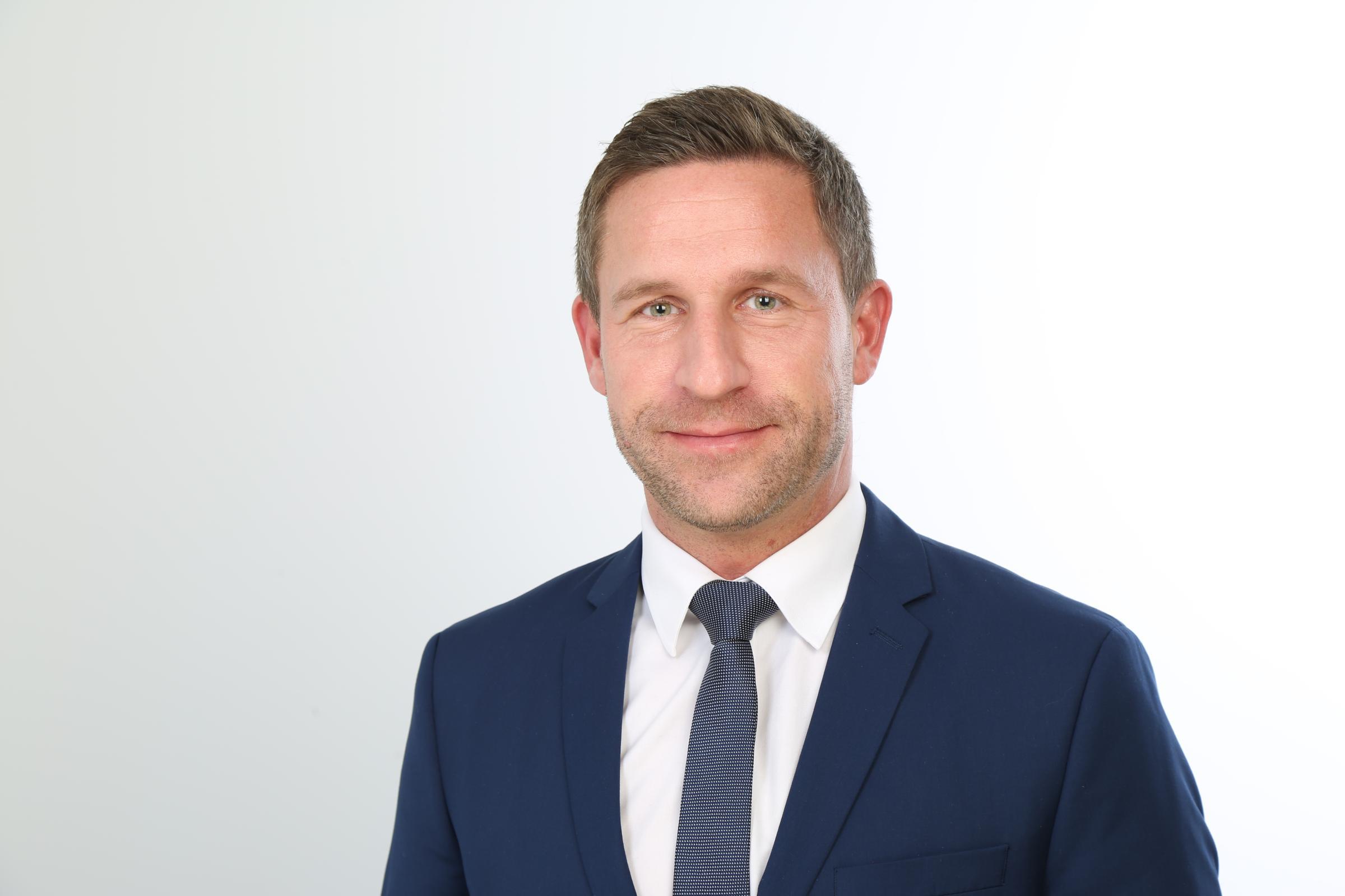 Experte Stefan Sievers von Hiscox trägt einen Anzug und Krawatte und blickt in die Kamera