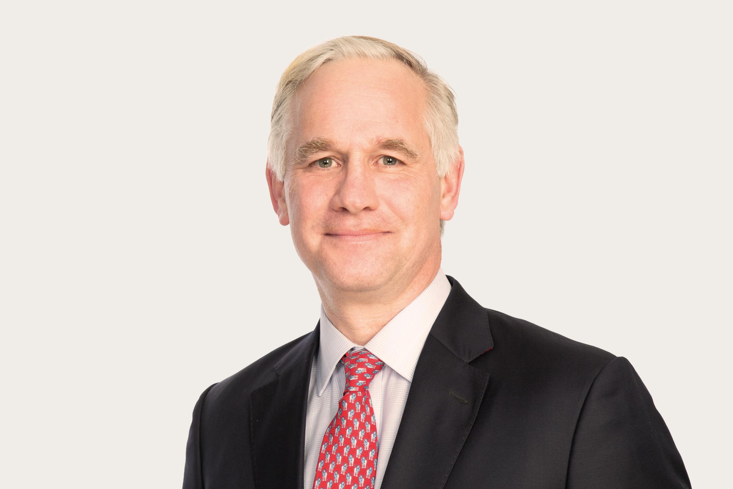 Das Bild zeigt Wolf von Buchwalt im Anzug mit einer Krawatte, er lächelt in die Kamera.