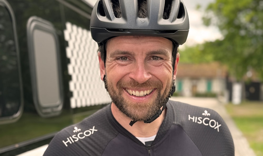 Jonas Deichmann, Leistungssportler aus Deutschland, lacht mit Fahrradhelm in die Kamera