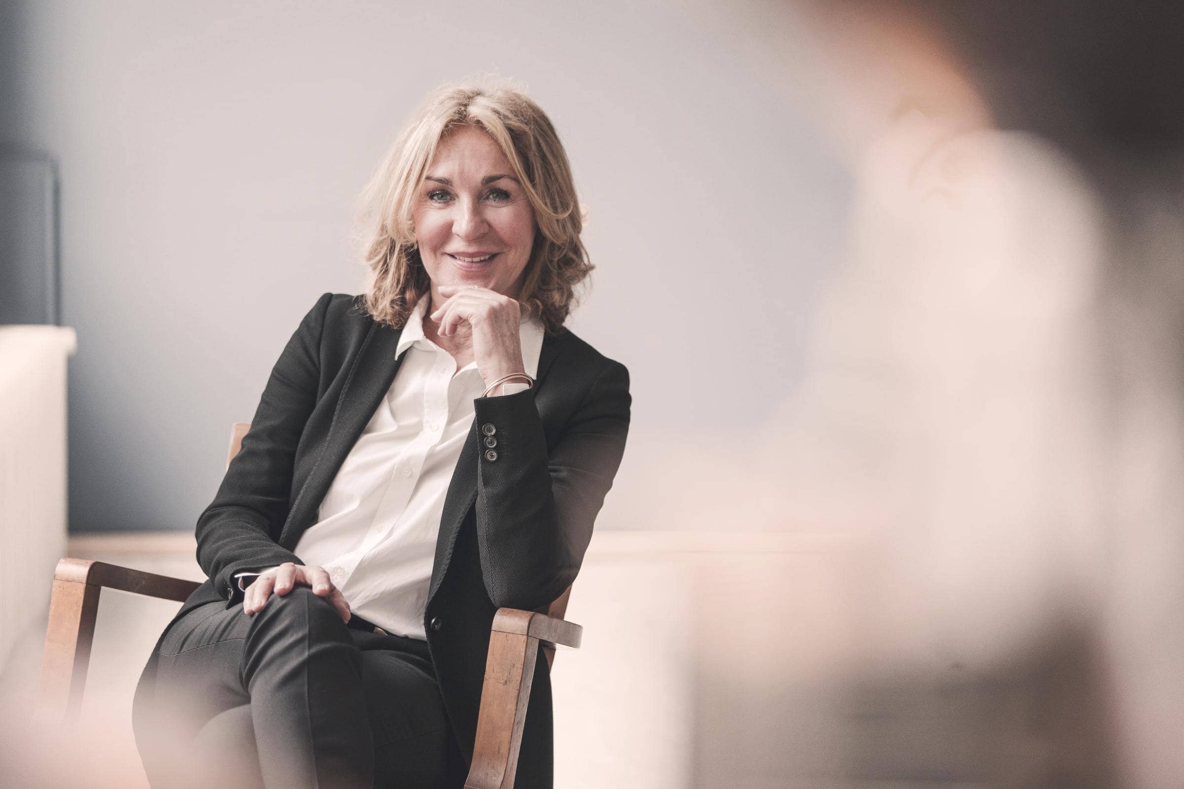 D&O-Versicherung von Hiscox: Sitzende Managerin im Anzug optimal versichert mit der 