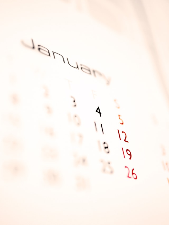 Verschwommenes Bild eines Kalenders, der den Monat Januar zeigt. Die Daten 4, 11, 18 und 25 sind schwarz markiert, während die Daten 5, 12, 19 und 26 rot markiert sind