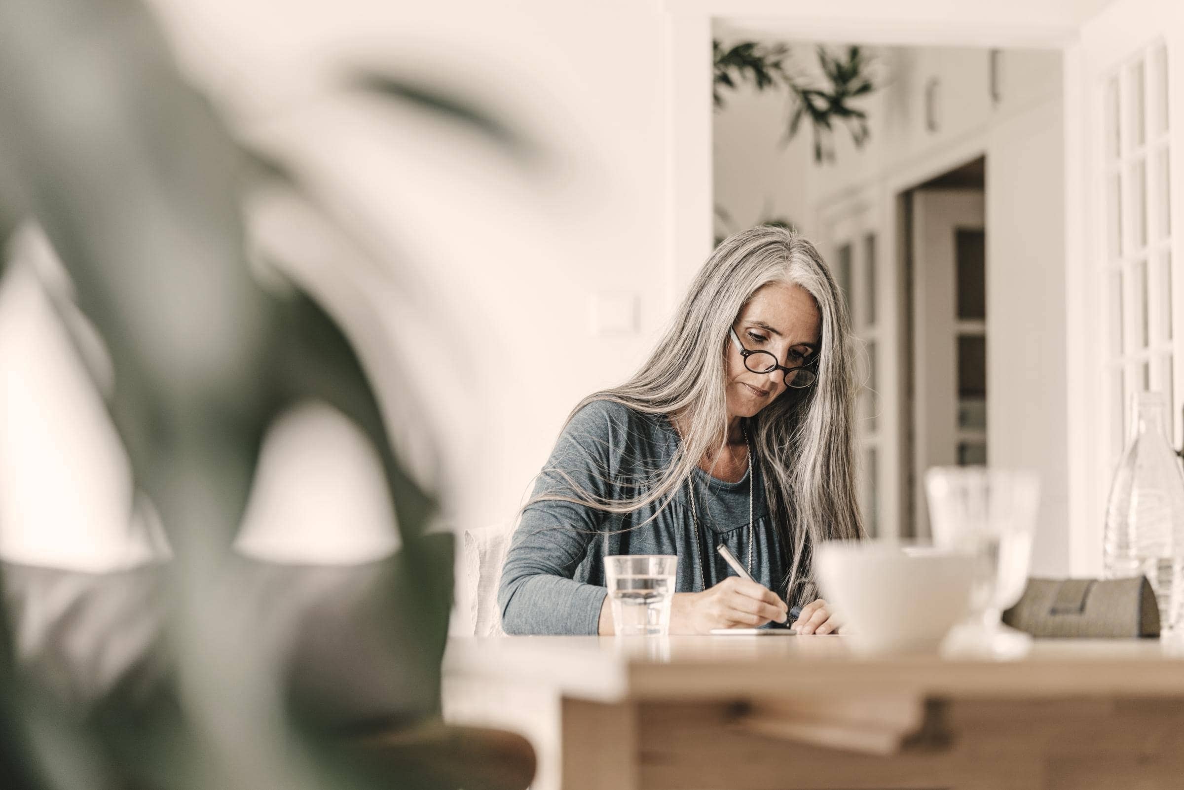 Übersetzer-Versicherung von Hiscox: Übersetzerin sitzt am Tisch und schreibt
