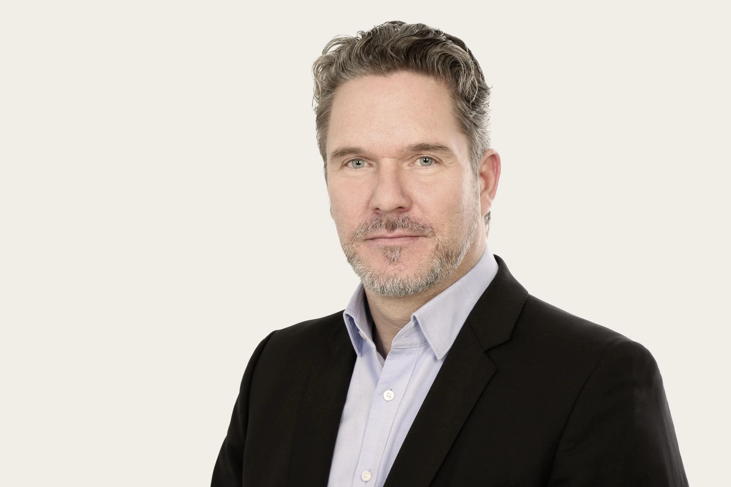 Markus Leenen trägt ein schwarzes Sakko über einem hellblauen Hemd.