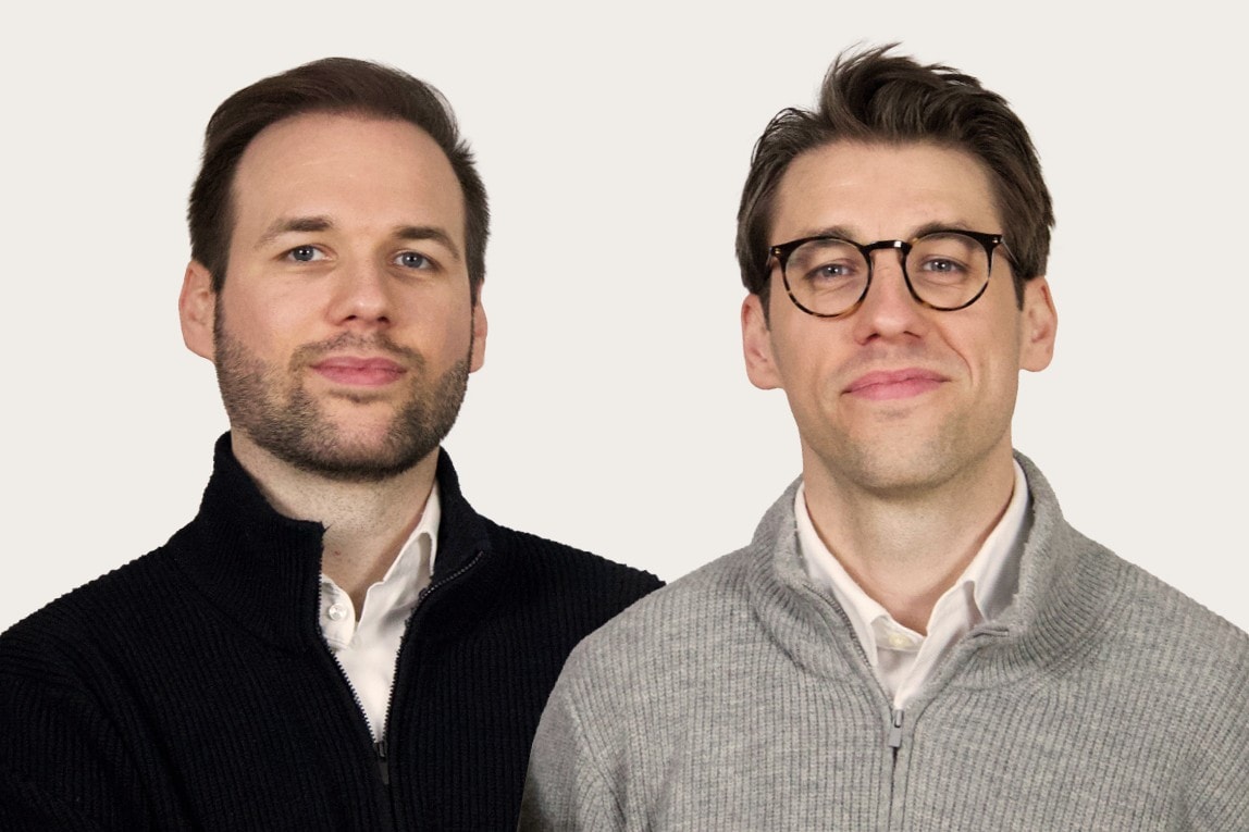 Niklas und Lukas Hufeld von Hufeld Rechtsanwälte stehen nebeneinander und lächeln in die Kamera
