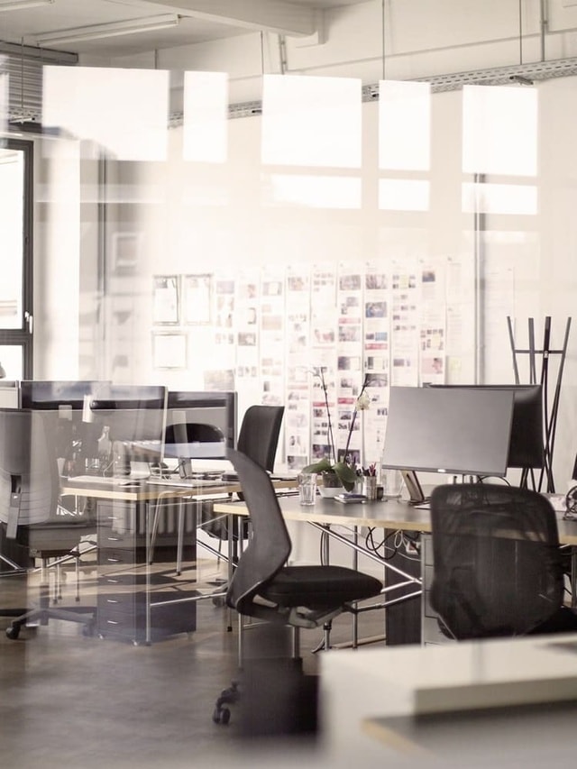 Sachversicherung von Hiscox: Büroraum mit Schreibtisch, Schreibtischstuhl und Büroeinrichtung