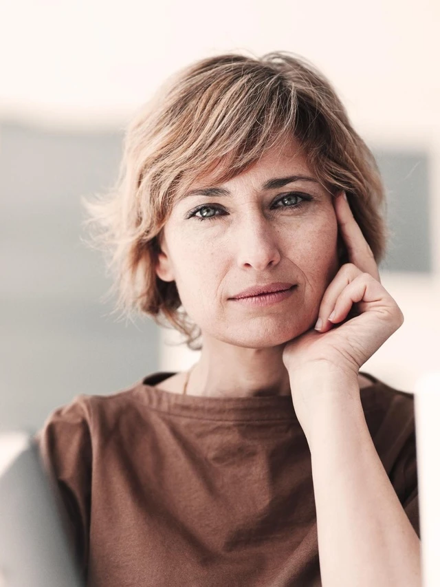 Versicherungen für Privatkunden von Hiscox: Frau blickt zufrieden in die Kamera