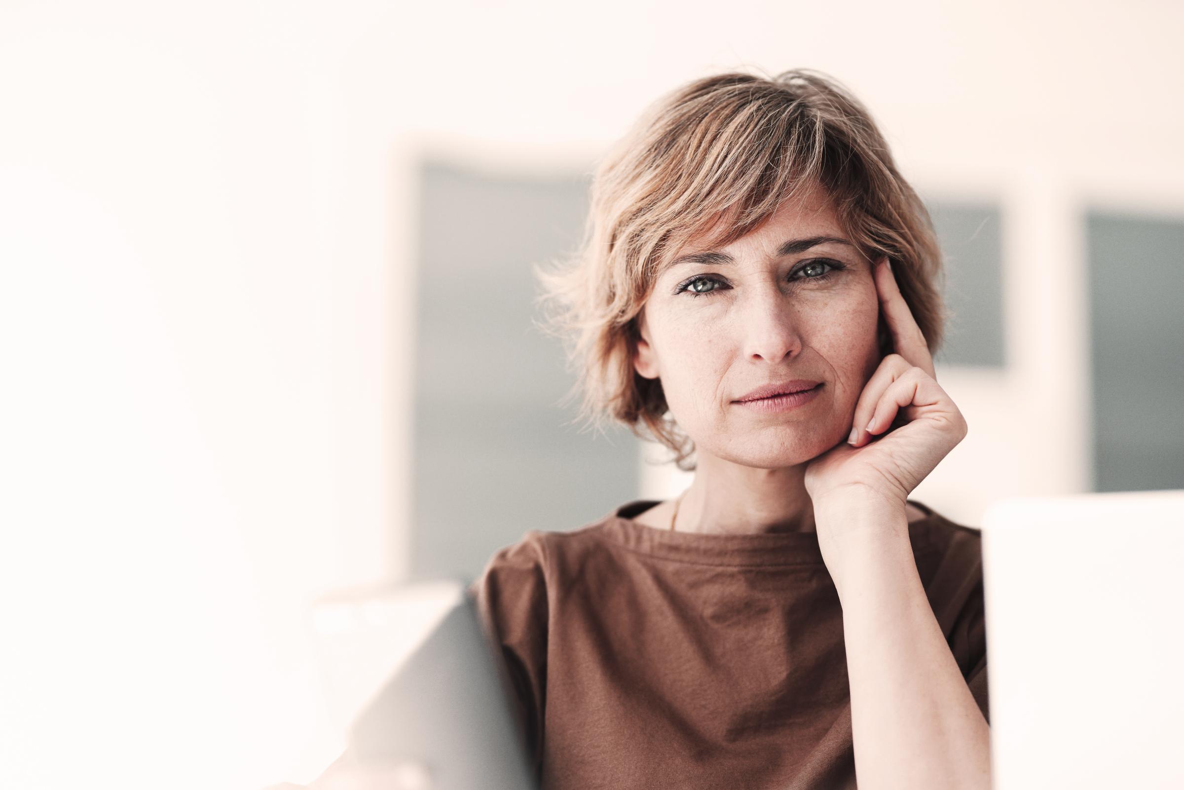 Versicherungen für Privatkunden von Hiscox: Frau blickt zufrieden in die Kamera